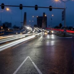 Нічне перехрестя з довгими смугами світла від автомобільних фар