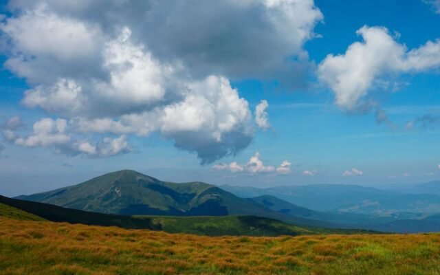 Карпатські пагорби, зелений луг і хмарне небо